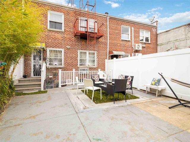 81-56 102nd Rd, Ozone Park, NY 11416 - rear view of house with an outdoor hangout area, fence, a patio, and brick siding