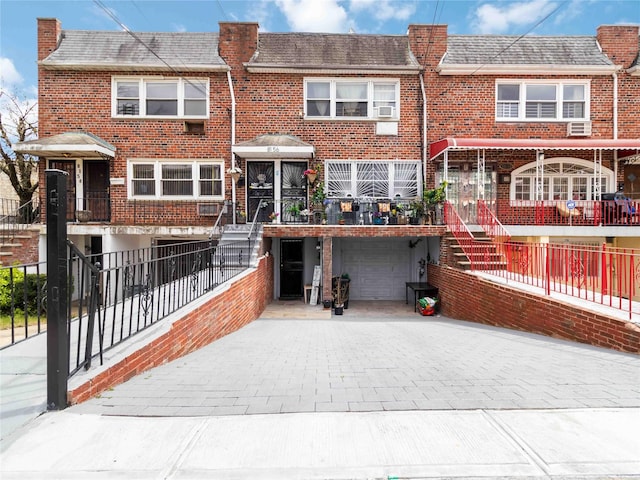 81-56 102nd Rd, Ozone Park, NY 11416 - view of front of house with brick siding, stairs, decorative driveway, and a garage