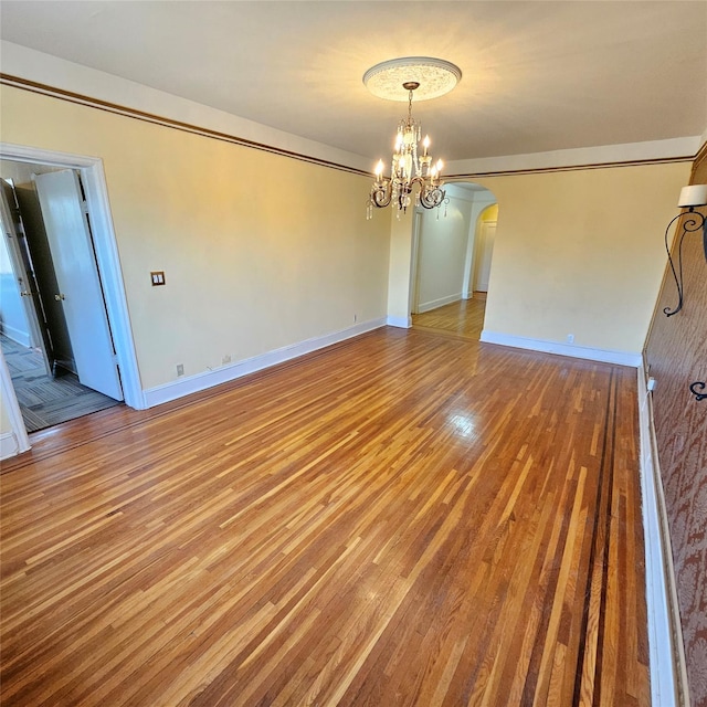 590 E 3rd St Unit 2-O, Mount Vernon, NY 10553 - unfurnished dining area featuring an inviting chandelier, arched walkways, baseboards, and wood finished floors