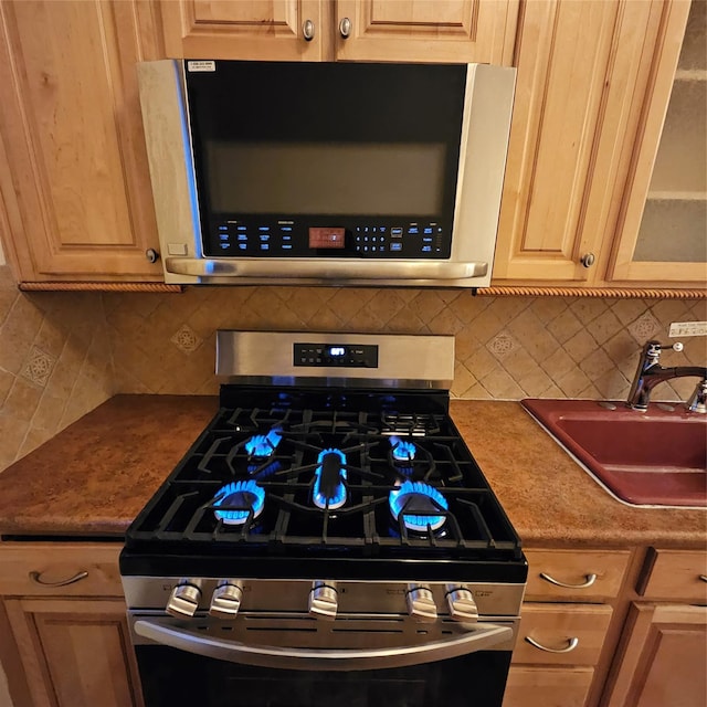 590 E 3rd St Unit 2-O, Mount Vernon, NY 10553 - kitchen with glass insert cabinets, appliances with stainless steel finishes, decorative backsplash, and a sink
