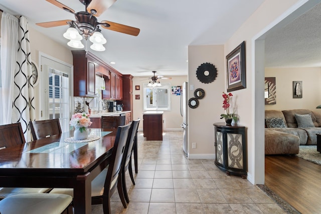 dining room with baseboards, ceiling fan, and light tile patterned flooring