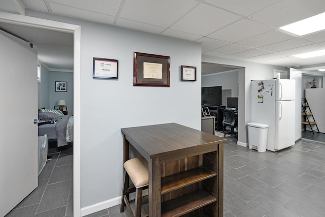 dining room with baseboards and a drop ceiling
