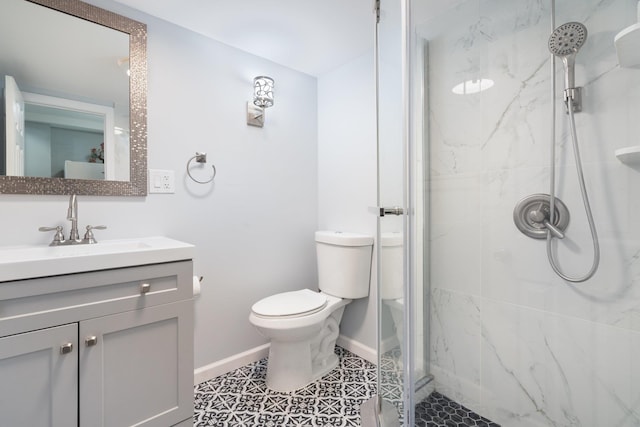bathroom with vanity, a marble finish shower, baseboards, and toilet