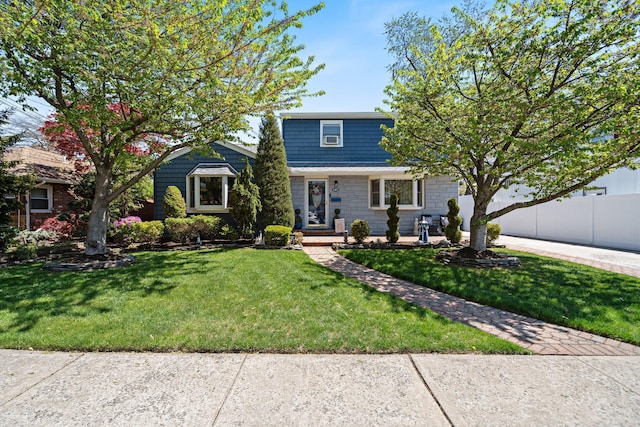 view of front of property featuring fence, driveway, and a front lawn
