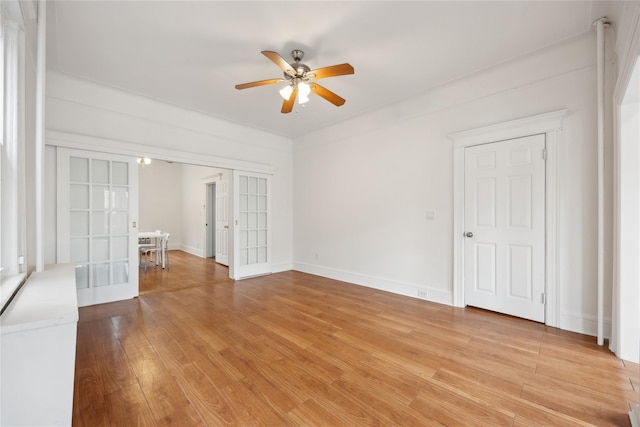 unfurnished bedroom featuring baseboards, a ceiling fan, french doors, and light wood-style flooring