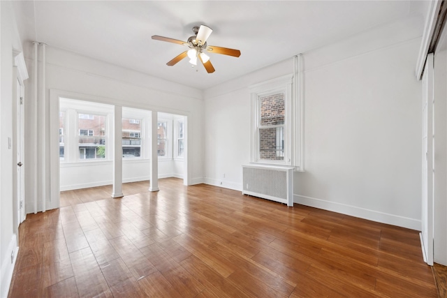 interior space with ceiling fan, radiator, baseboards, and wood finished floors