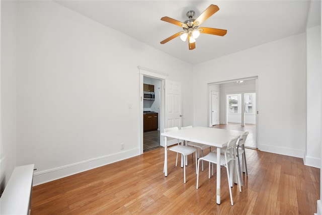 dining space featuring ceiling fan, baseboards, and light wood-type flooring