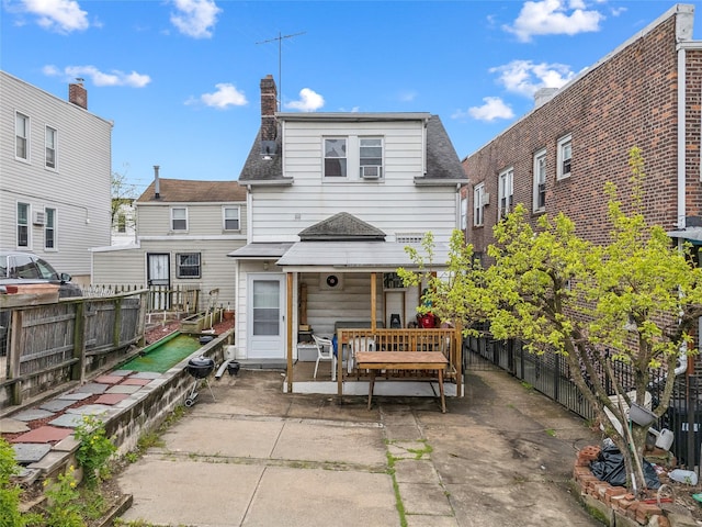 back of house featuring fence, a patio, and a shingled roof