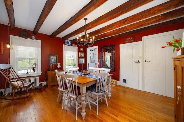 dining room featuring beam ceiling, a chandelier, plenty of natural light, and light wood-style flooring
