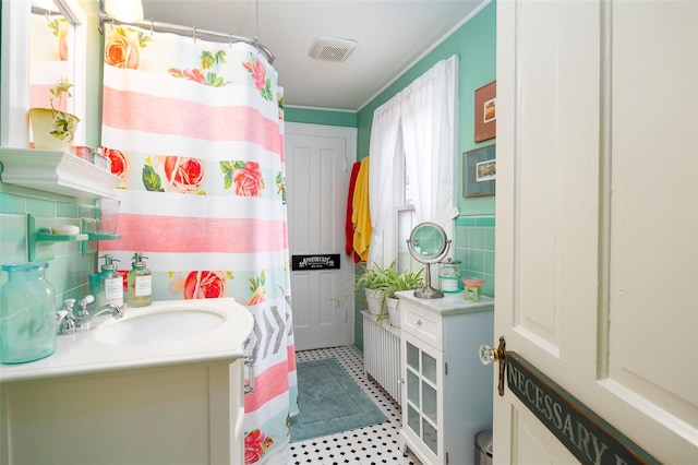 bathroom featuring visible vents, tile walls, curtained shower, vanity, and ornamental molding