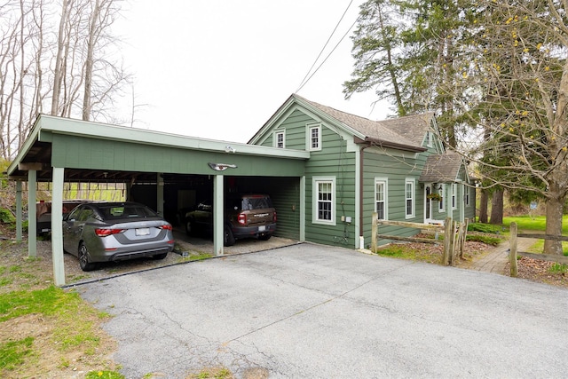 view of front of property with roof with shingles, driveway, and a carport