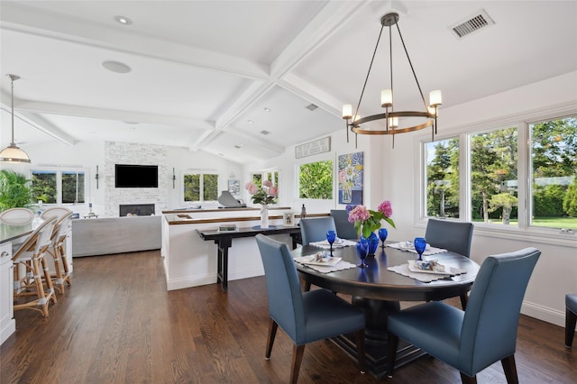dining room with dark wood-style flooring, lofted ceiling with beams, an inviting chandelier, a stone fireplace, and visible vents