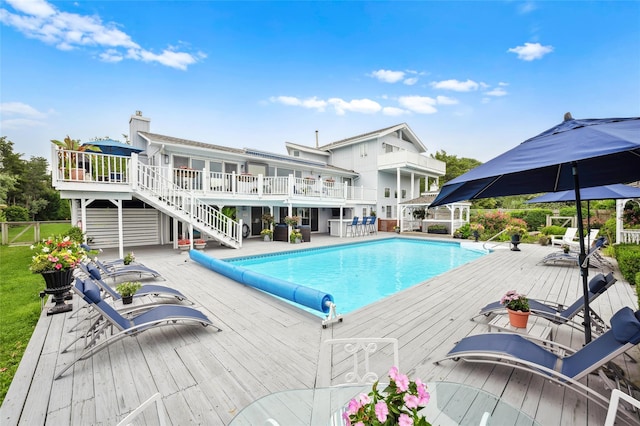 view of pool featuring stairs, a wooden deck, a fenced in pool, and fence