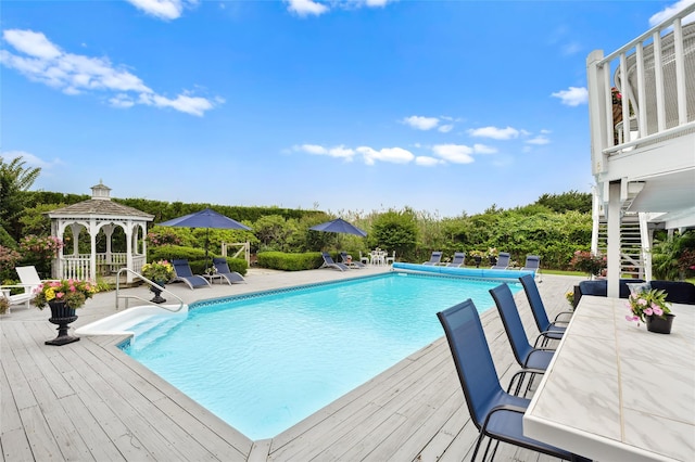 pool with stairway, a deck, a gazebo, and a patio