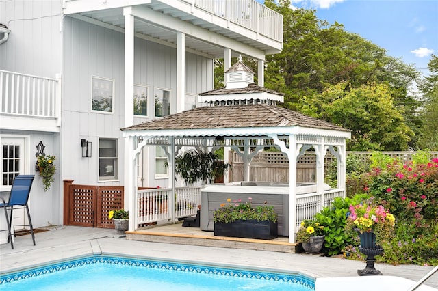exterior space featuring a gazebo, fence, a jacuzzi, and a deck