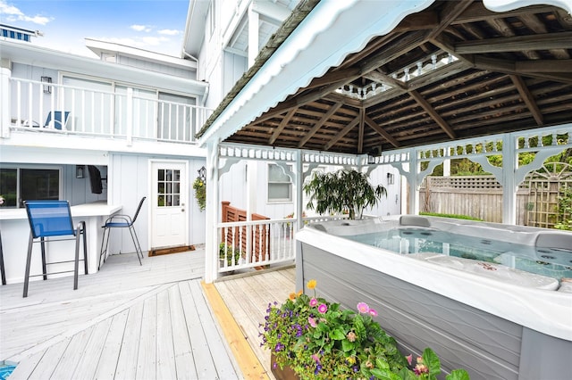 wooden terrace featuring a gazebo and a hot tub