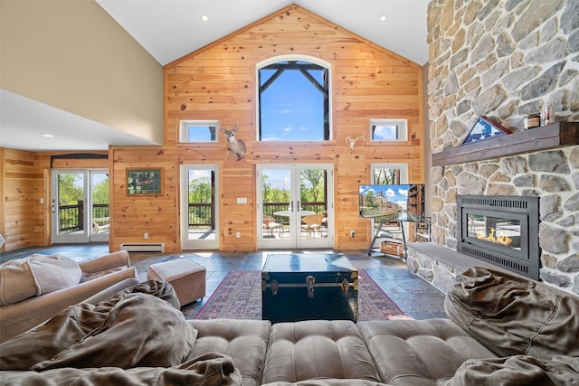 535 County Route 22, Middletown, NY 10940 - living room featuring high vaulted ceiling, wooden walls, stone tile flooring, baseboard heating, and a stone fireplace
