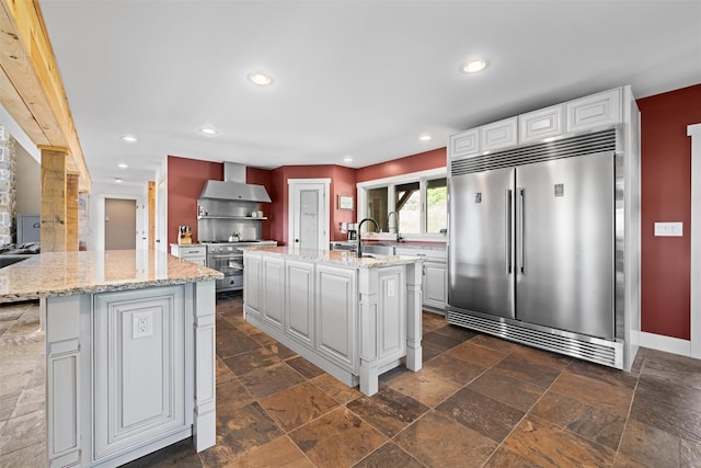 535 County Route 22, Middletown, NY 10940 - kitchen featuring high end appliances, an island with sink, wall chimney exhaust hood, stone tile floors, and recessed lighting