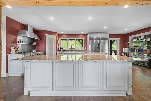 535 County Route 22, Middletown, NY 10940 - kitchen with built in fridge, recessed lighting, white cabinetry, wall chimney exhaust hood, and light stone counters