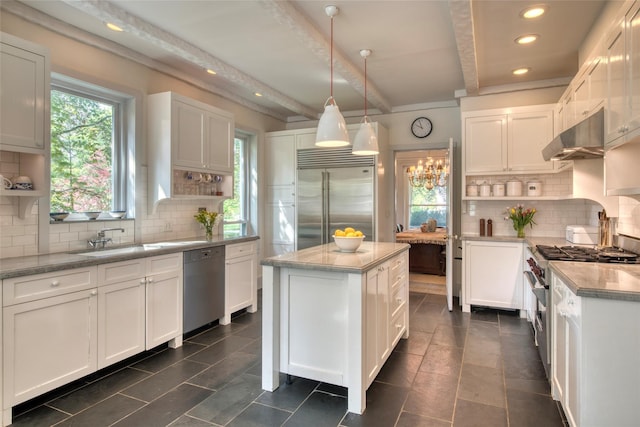 kitchen with high quality appliances, open shelves, decorative backsplash, and a sink