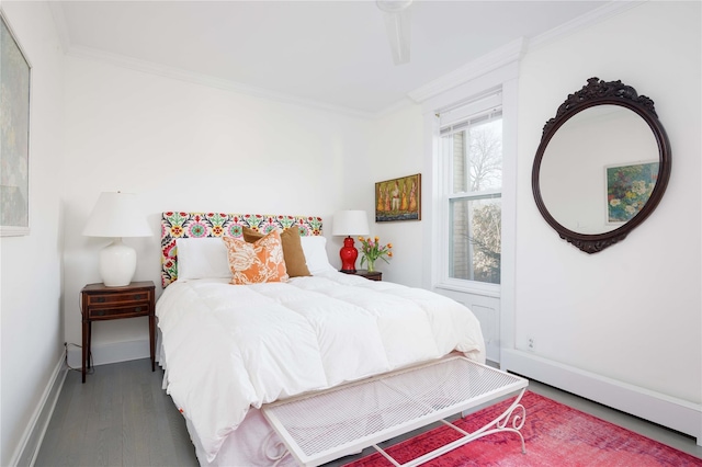 bedroom with crown molding, baseboards, and wood finished floors