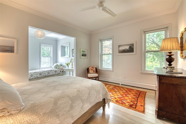 bedroom with ornamental molding, light wood finished floors, a ceiling fan, and baseboard heating