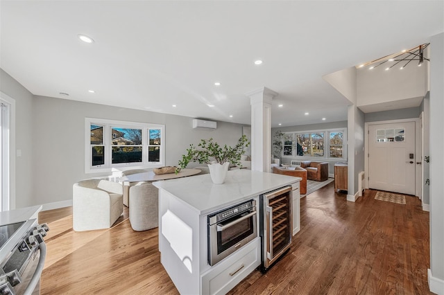 kitchen featuring beverage cooler, open floor plan, stainless steel electric stove, and a wealth of natural light