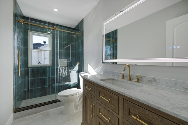 bathroom featuring toilet, a shower stall, and vanity