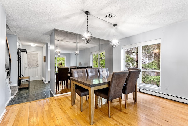 dining area with visible vents, an inviting chandelier, stairway, a textured ceiling, and hardwood / wood-style flooring
