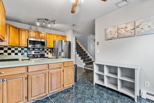 kitchen featuring stainless steel appliances, a baseboard heating unit, a sink, and visible vents