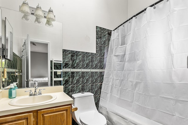 bathroom with tile walls, shower / bath combo, vanity, and toilet