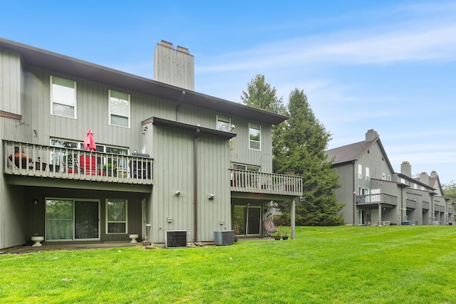 back of house featuring a lawn, central AC, and a chimney
