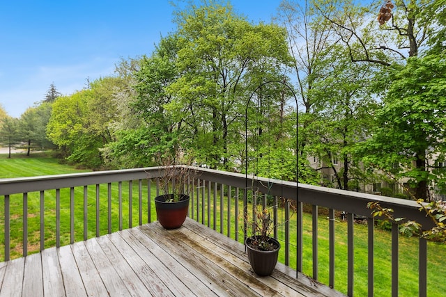 wooden deck featuring a lawn