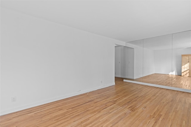 unfurnished living room with baseboards and light wood-style floors
