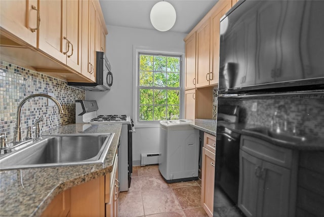 kitchen featuring stainless steel gas range oven, stone countertops, a baseboard heating unit, a sink, and decorative backsplash
