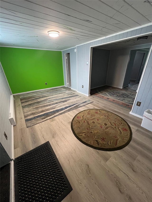 interior space with baseboards, wood finished floors, and wooden ceiling