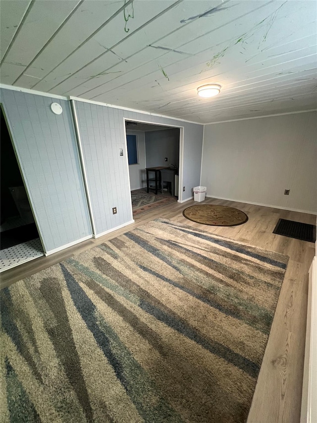finished below grade area featuring wooden walls and wood finished floors