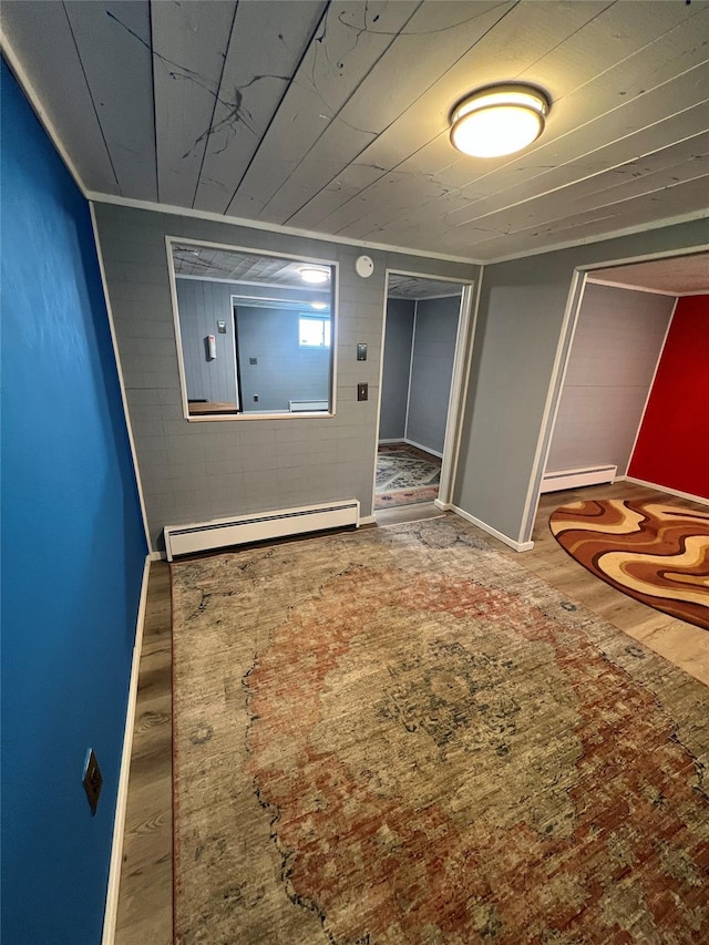 spare room featuring baseboards, wood finished floors, and baseboard heating