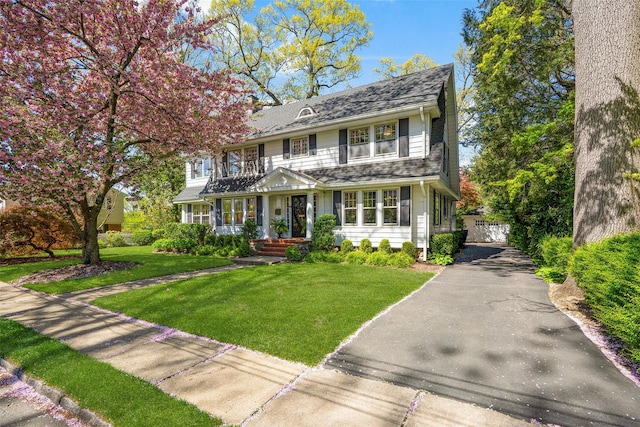 view of front of house with a front lawn and aphalt driveway