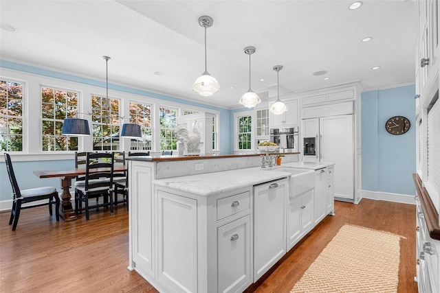 kitchen with baseboards, a sink, white cabinetry, and stainless steel oven