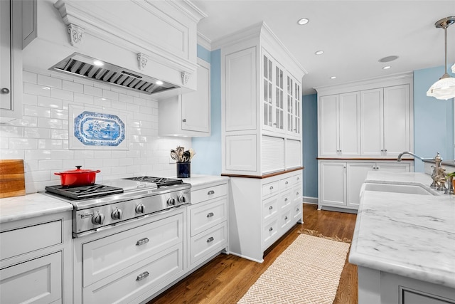 kitchen with dark wood-style flooring, a sink, stainless steel gas cooktop, white cabinetry, and tasteful backsplash