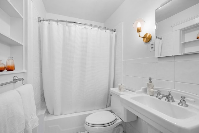 full bathroom featuring toilet, tile walls, a sink, and shower / bath combo