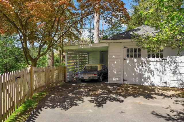 view of home's exterior featuring aphalt driveway and fence