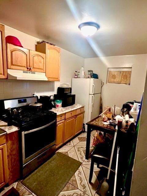 3231 Grace Ave, Bronx, NY 10469 - kitchen featuring backsplash, stainless steel range with gas stovetop, light tile patterned floors, light countertops, and under cabinet range hood