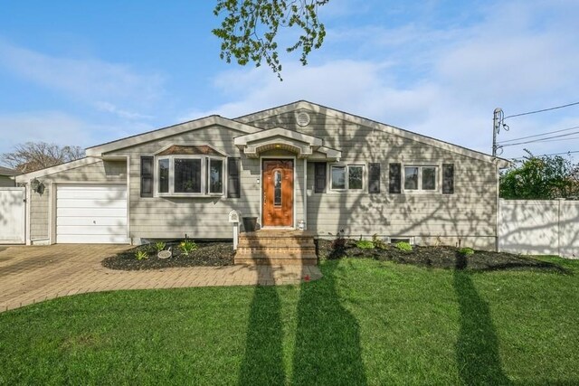ranch-style house with decorative driveway, an attached garage, and a front yard
