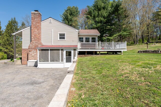 163 Smith Rd, Poughkeepsie, NY 12603 - rear view of house with aphalt driveway, a wooden deck, a chimney, a sunroom, and a yard