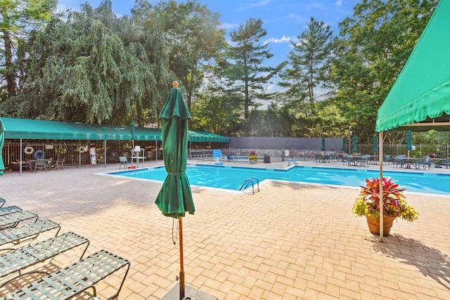 185 Old Pond Ct Unit 185, Jericho, NY 11753 - community pool with fence, a patio, and view of wooded area