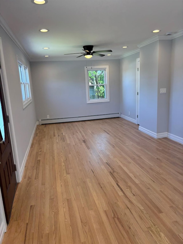 empty room with light wood-type flooring, a ceiling fan, baseboard heating, and a wealth of natural light
