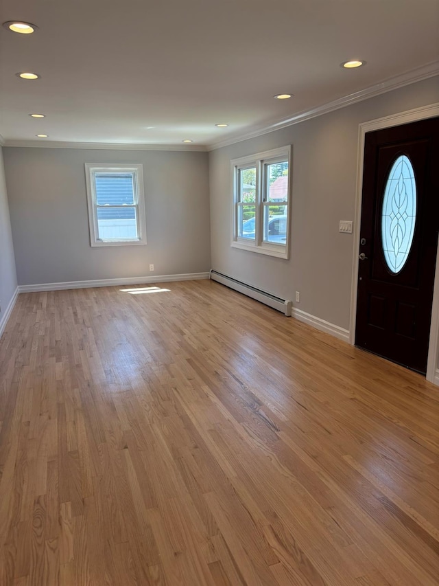 entryway featuring baseboards, ornamental molding, light wood-style floors, and a baseboard heating unit
