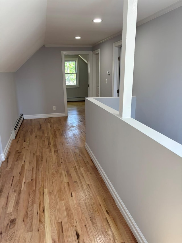 hall with baseboards, light wood finished floors, lofted ceiling, and a baseboard heating unit